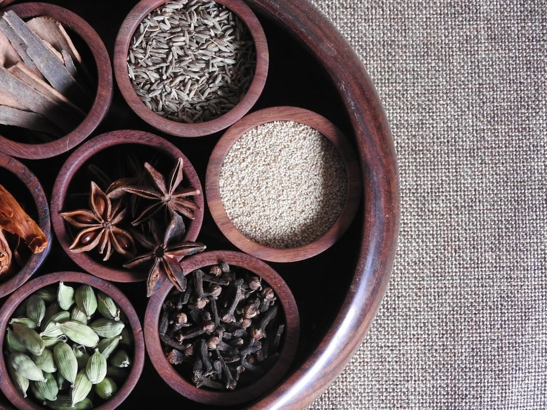 Whole spices in wooden bowl cinnamon star anise cardamom