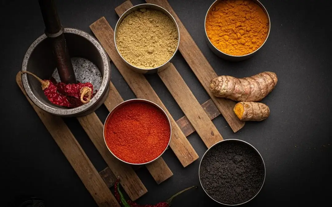 Ground spices powders in wooden bowl turmeric chili cumin